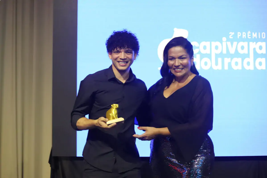 Troféu do Prêmio Capivara Dourada sendo entregue no palco